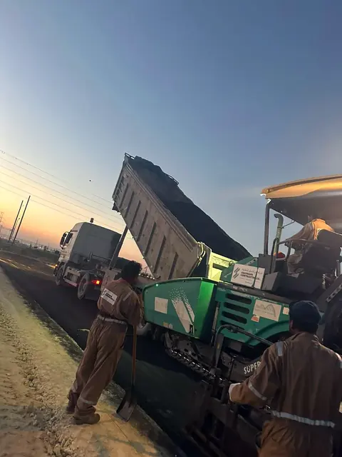 Paving train working into the evening